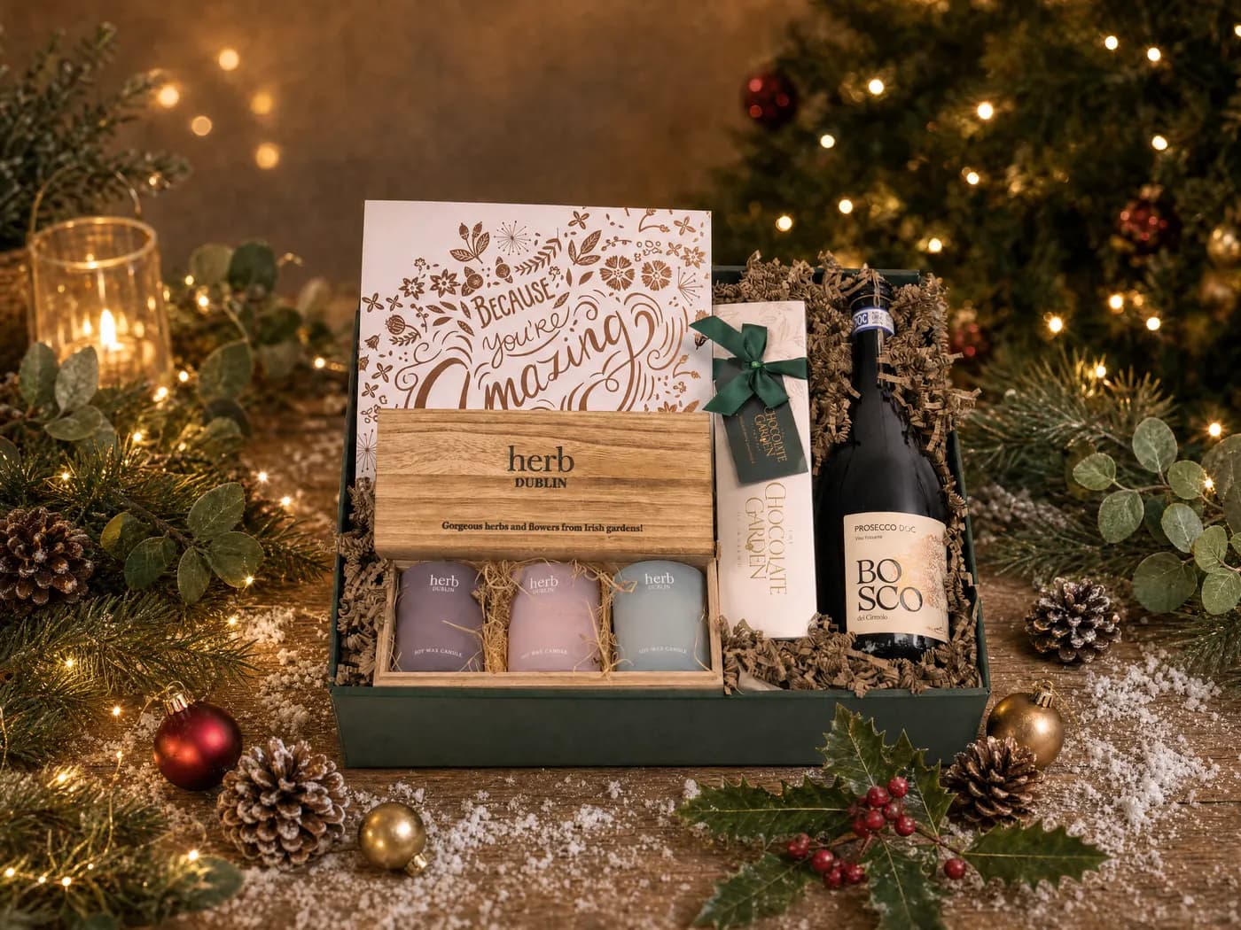 The Because You’re Amazing Hamper dressed for Christmas, with a Herb Dublin candle trio, a bottle of Prosecco and a Handmade Soap Company set