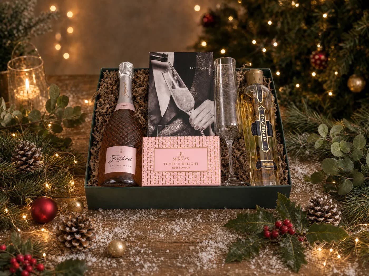 The Rosé and Crystal Celebration Hamper dressed for Christmas, with sparkling rosé, boxed Champagne flutes, Turkish delight and elderflower liqueur
