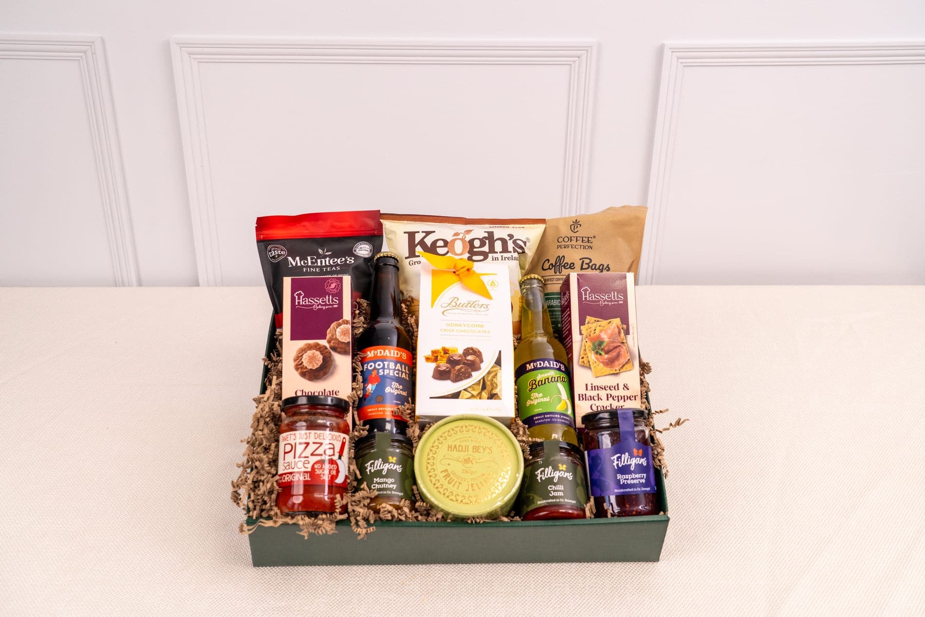 An Irish food hamper packed with crisps, tea, preserves and coffee in a green gift box